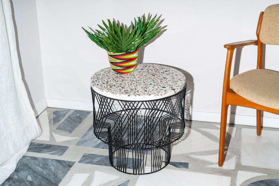 Terrazzo Side Table by Bend, showing terrazzo side table with chair in live shot.