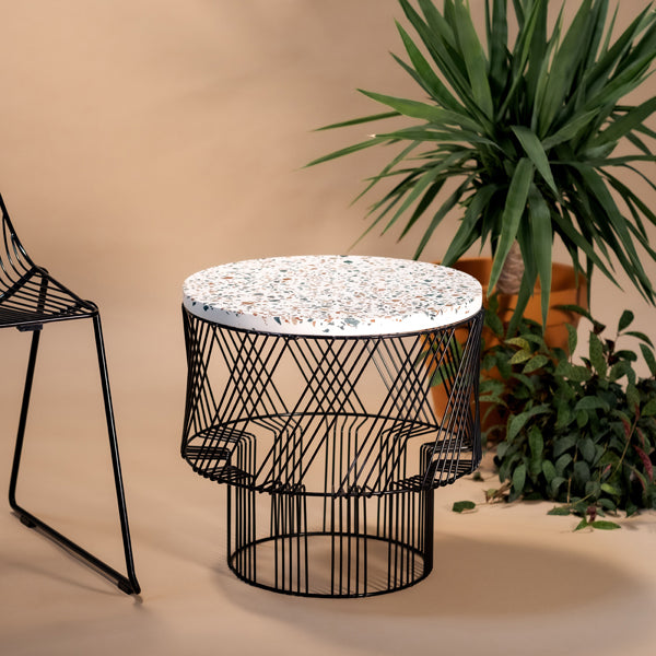 Terrazzo Side Table by Bend, showing terrazzo side table with chair in live shot.
