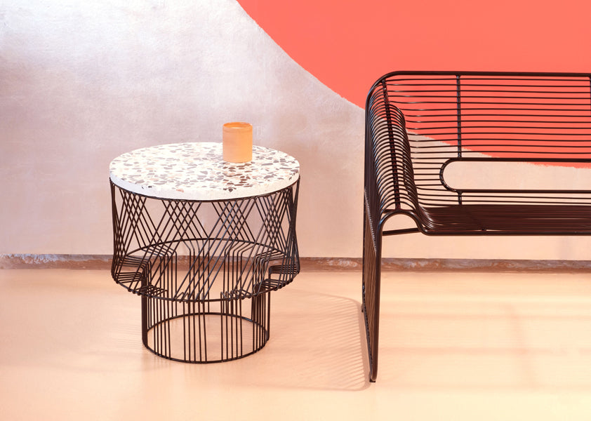 Terrazzo Side Table by Bend, showing terrazzo side table with chair in live shot.