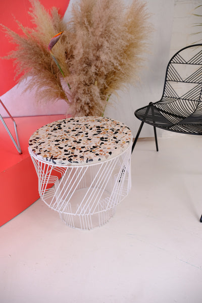 Terrazzo Side Table by Bend, showing terrazzo side table with chair in live shot.