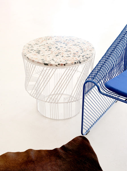 Terrazzo Side Table by Bend, showing terrazzo side table with chair in live shot.