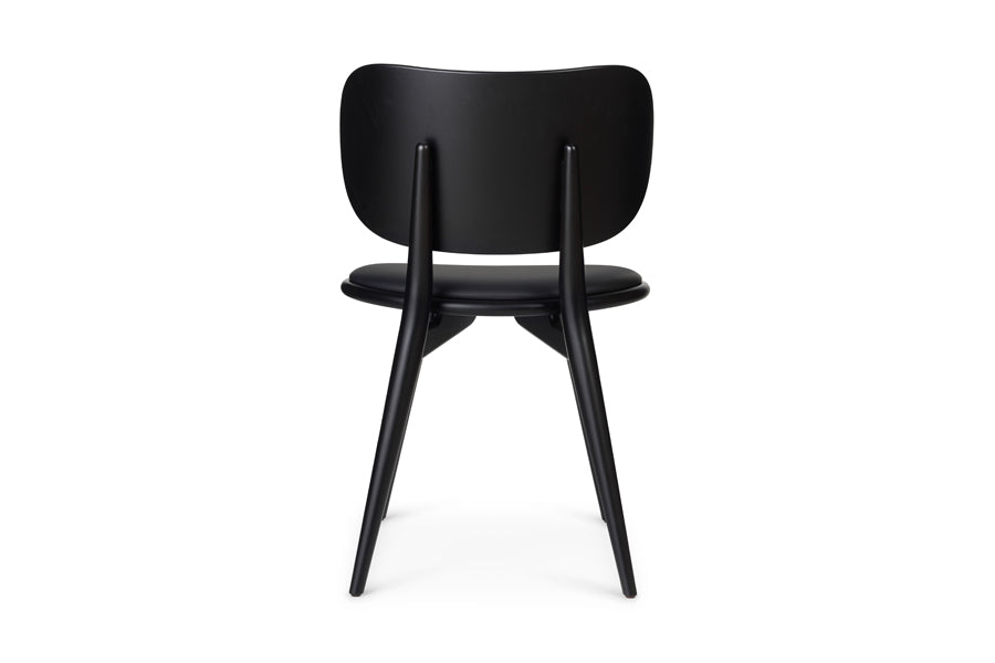 The Dining Chair by Mater, showing back view of the dining chair in black stained beech wood/black leather seat.
