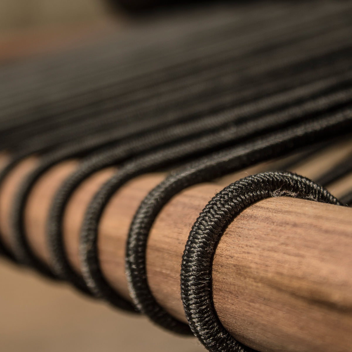 Gallagher Lounge Chair by Tronk Design, showing detail view of black bungee cords of gallagher lounge chair.