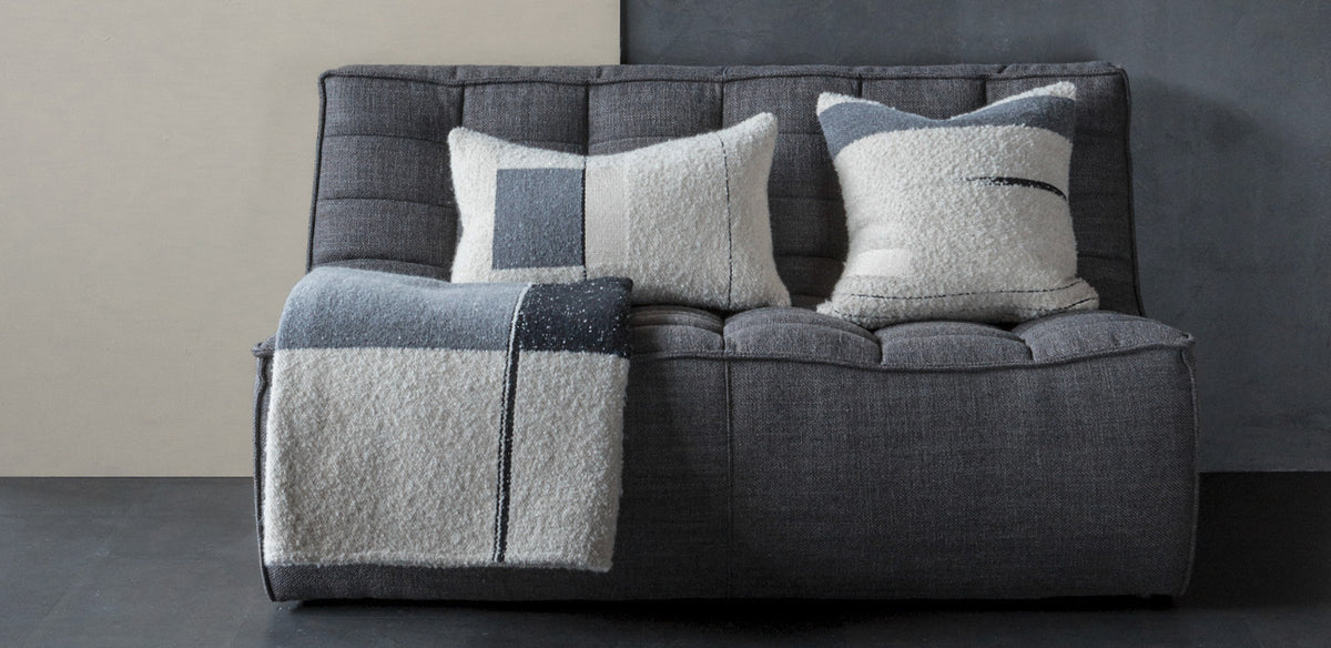 Urban Cushion by Ethnicraft, showing front view of urban cushions with throw in live shot.