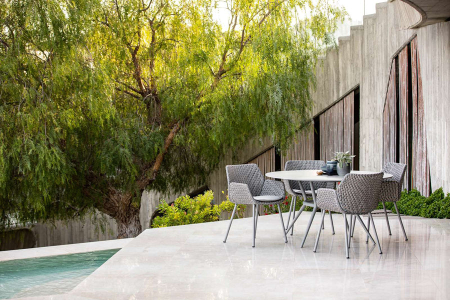 Vibe Outdoor Dining Chair by Cane-Line, showing vibe outdoor dining chairs with table in live shot.
