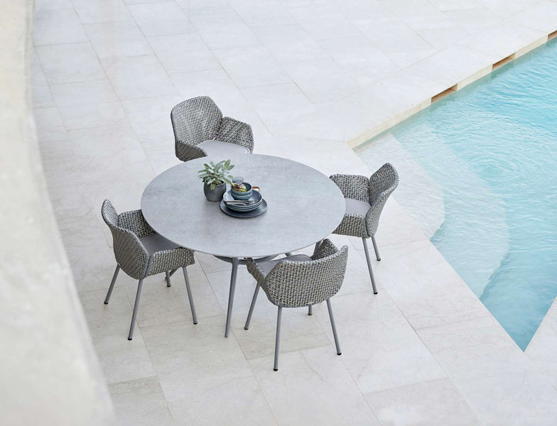 Vibe Outdoor Dining Chair by Cane-Line, showing vibe outdoor dining chairs with table in live shot.