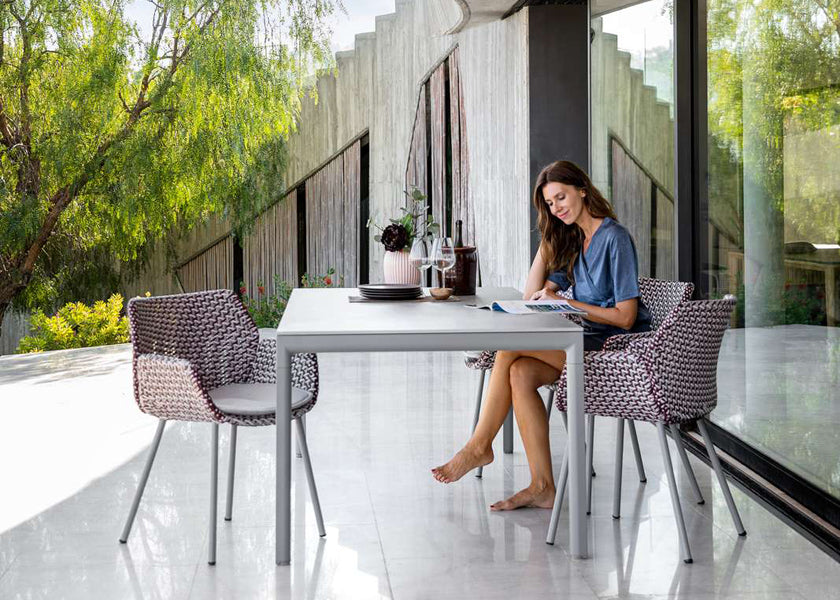 Vibe Outdoor Dining Chair by Cane-Line, showing vibe outdoor dining chairs with table in live shot.