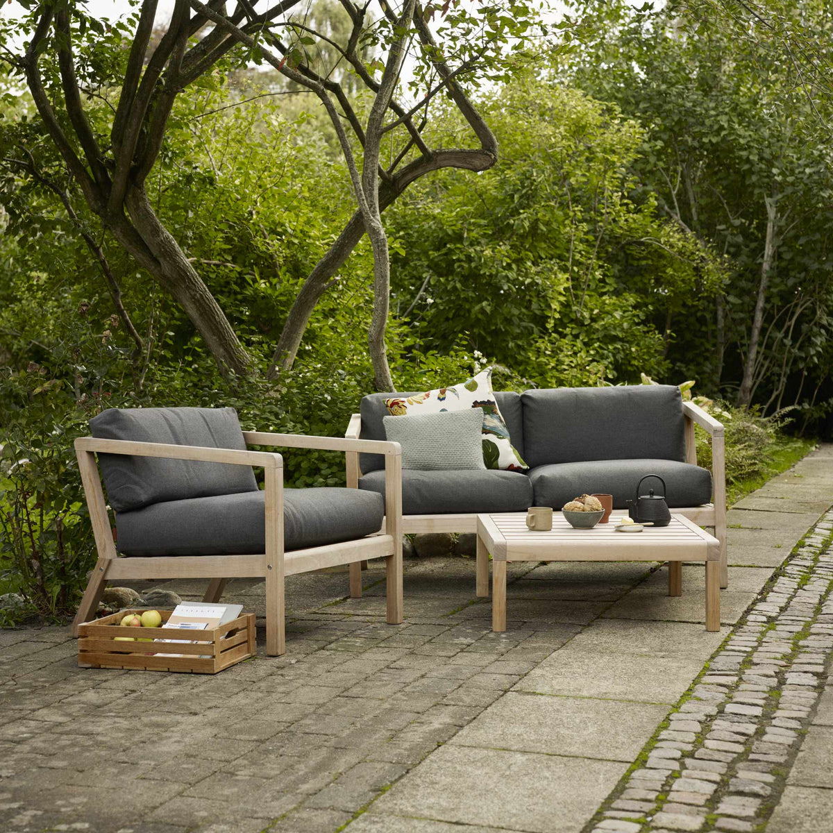 Virkelyst 2-Seater Sofa by Skagerak, showing virkelyst sofa with chair & side table in live shot.