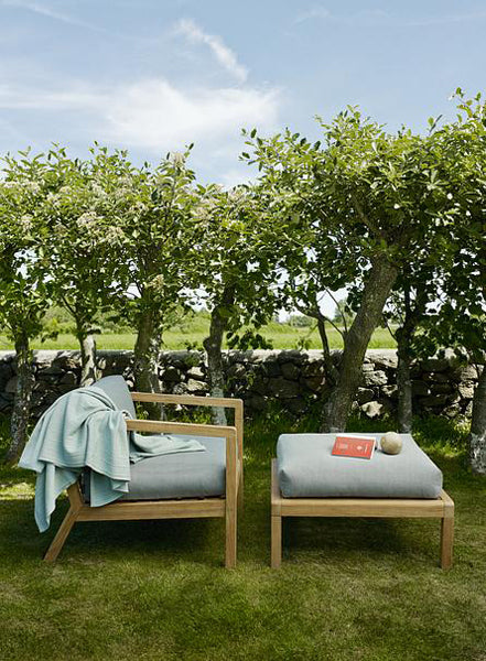Virkelyst Chair by Skagerak, showing virkelyst chair with pouf in live shot.