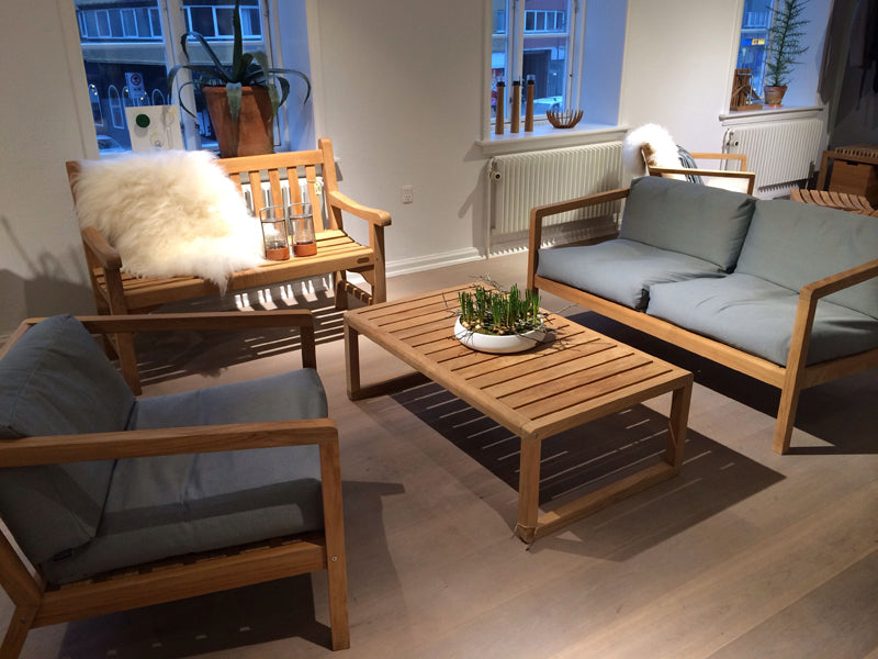 Virkelyst Chair by Skagerak, showing virkelyst chair with sofa & coffee table in live shot.