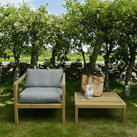 Virkelyst Chair by Skagerak, showing virkelyst chair with side table in live shot.