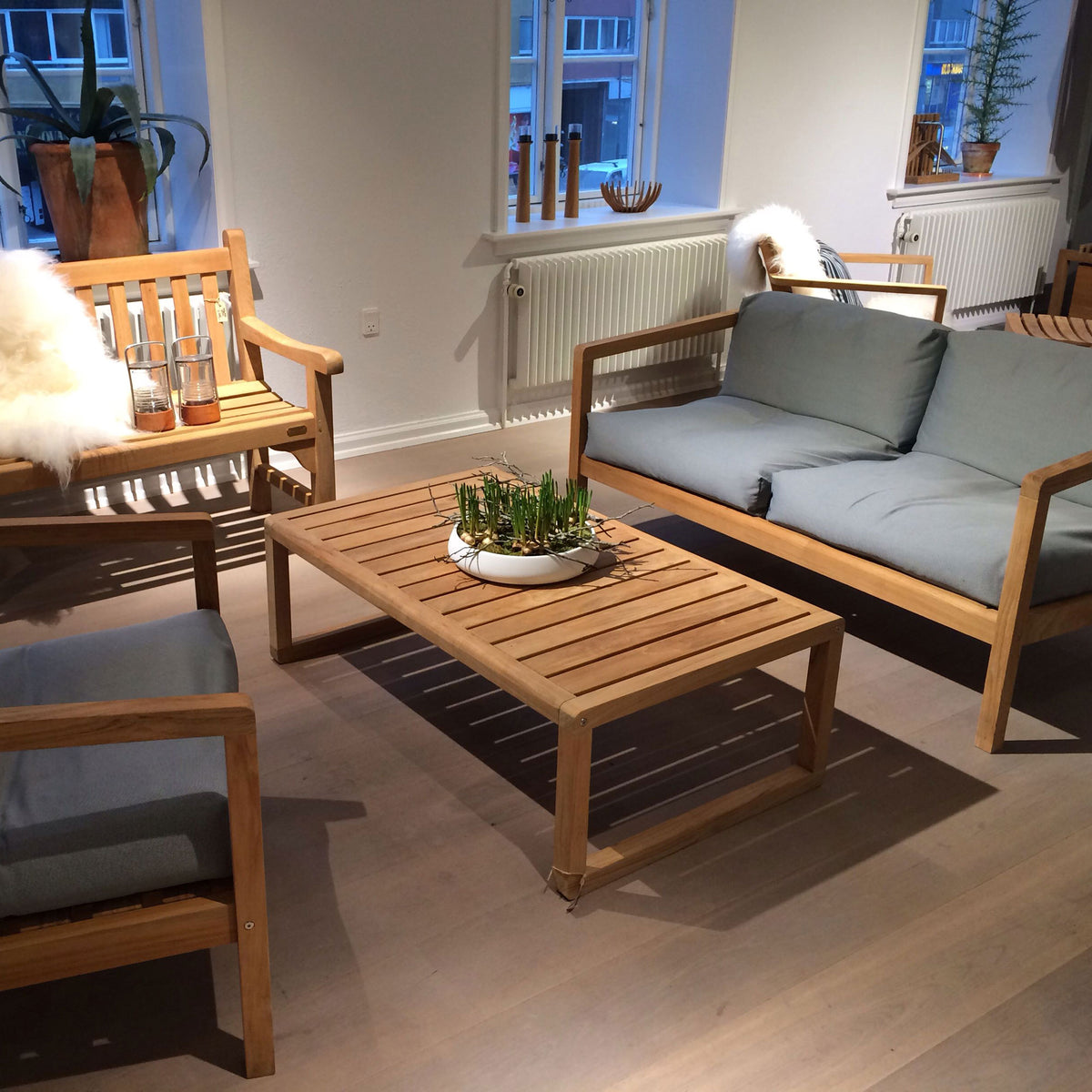 Virkelyst Coffee Table by Skagerak, showing virkelyst coffee table with sofas & chair in live shot.