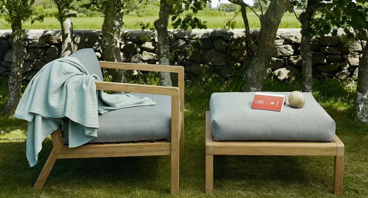 Virkelyst Pouf by Skagerak, showing virkelyst pouf with chair in live shot.