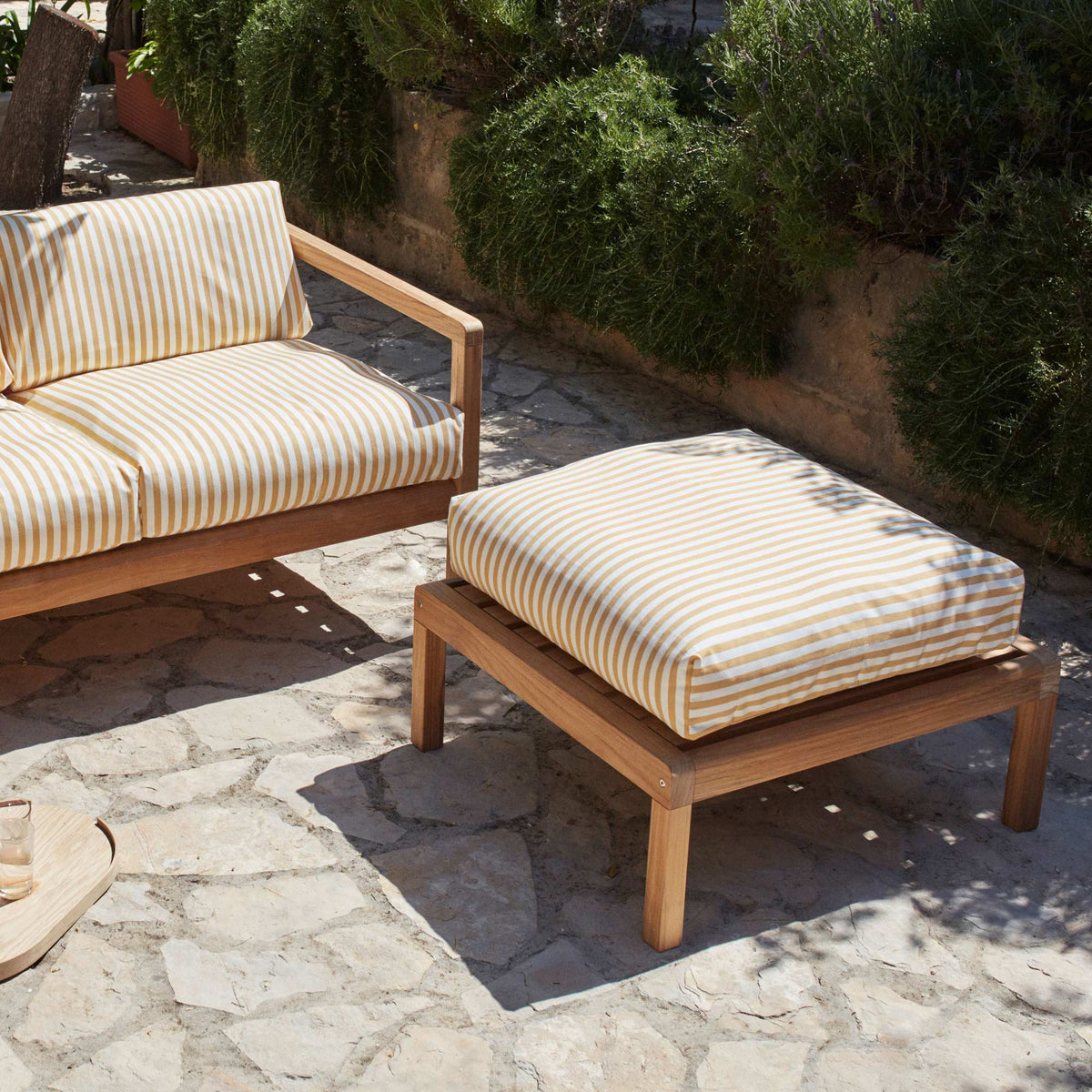 Virkelyst Pouf by Skagerak, showing virkelyst pouf with sofa in live shot.