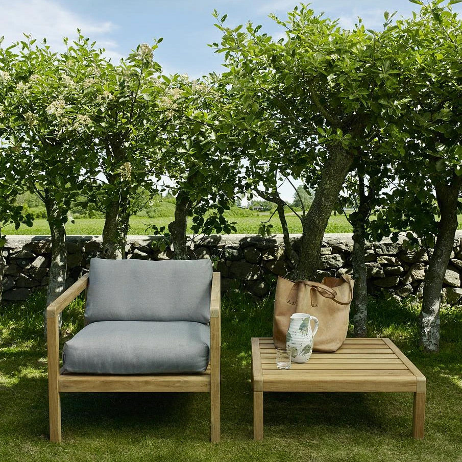 Virkelyst Side Table by Skagerak, showing virkelyst side table with chair in live shot.