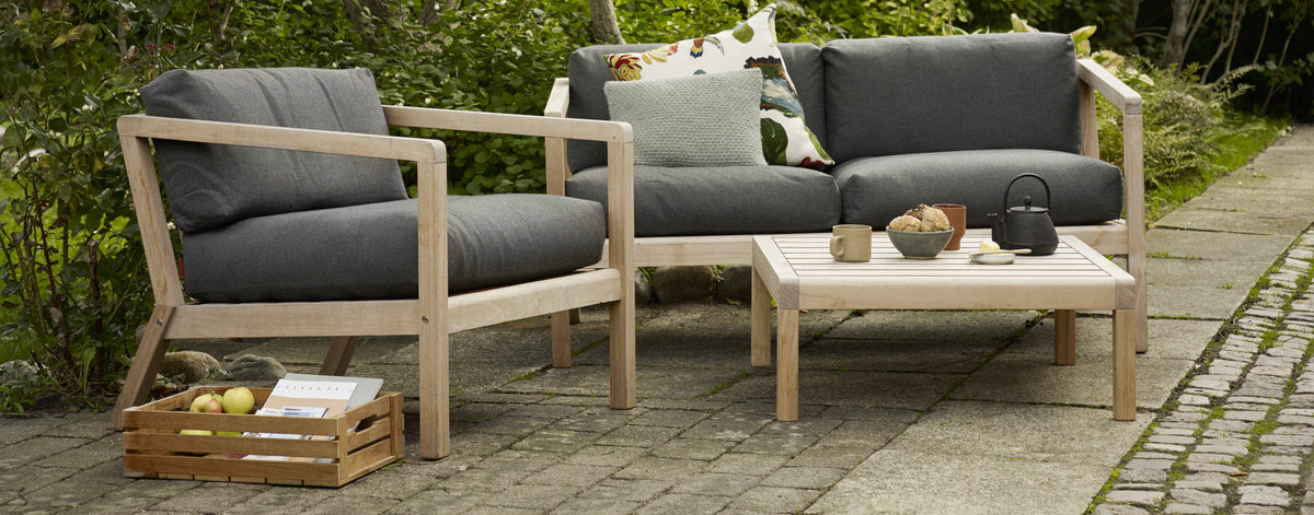 Virkelyst Side Table by Skagerak, showing virkelyst side table with sofa & chair in live shot.