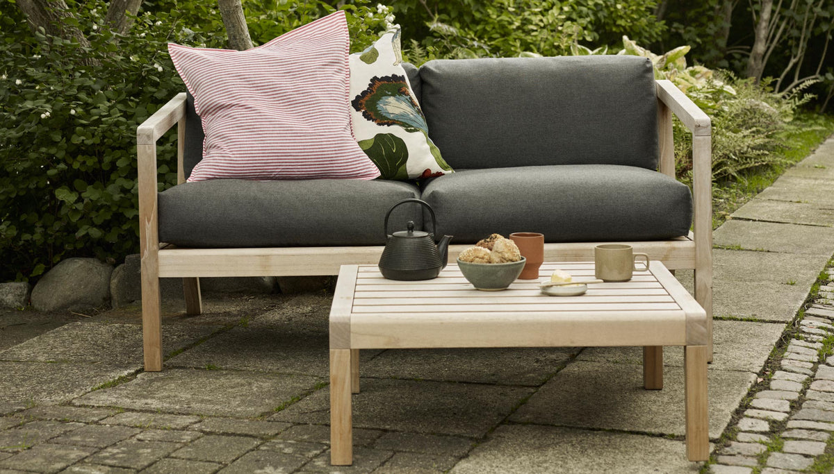 Virkelyst Side Table by Skagerak, showing virkelyst side table with sofa in live shot.