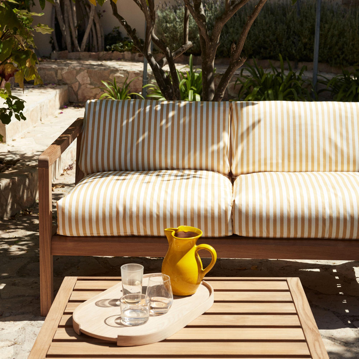 Virkelyst Side Table by Skagerak, showing closeup view of virkelyst side table with sofa in live shot.