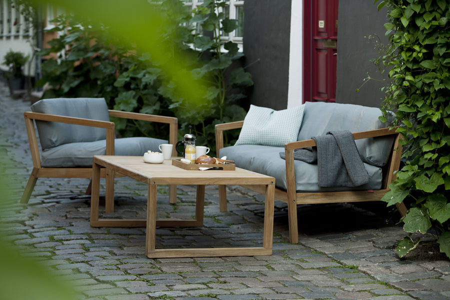 Virkelyst 2-Seater Sofa by Skagerak, showing virkelyst sofa with chair & coffee table in live shot.