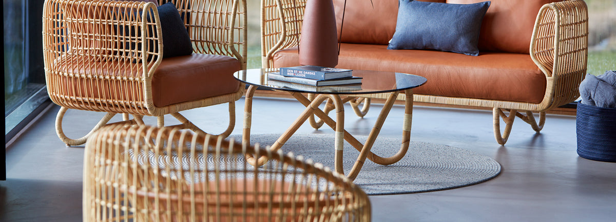 Wave Indoor Large Glass Coffee Table by Cane-Line, showing wave indoor large glass coffee table with sofa & chairs in live shot.