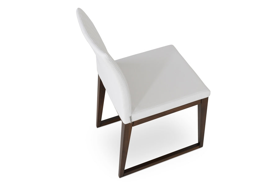 Zeyno Sled Wood Chair by sohoConcept, showing angle view in white leatherette with walnut finish base.