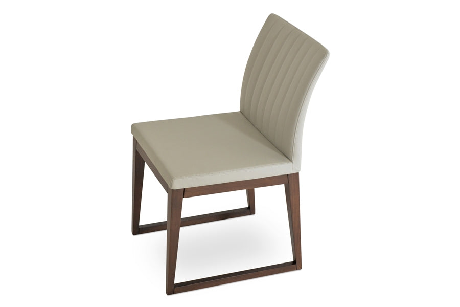 Zeyno Sled Wood Chair by sohoConcept, showing angle view in light grey leatherette with walnut finish base.