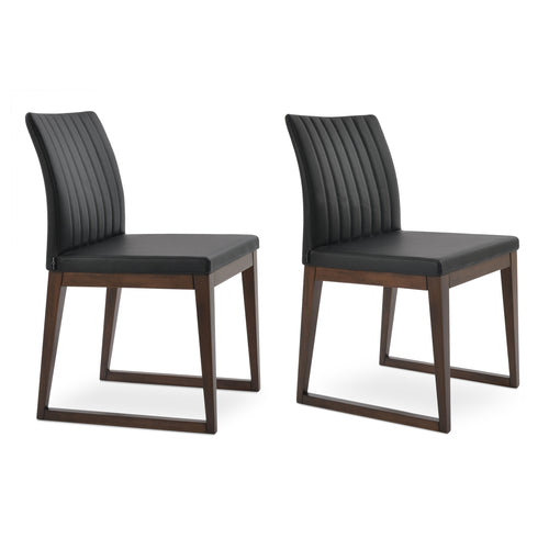 Zeyno Sled Wood Chair by sohoConcept, showing two chairs in black leatherette with walnut finish base.